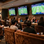Engaged bettors celebrating their wins in a sports betting lounge at 99 win.