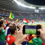 Classement de la coupe du monde de football 2026 avec des fans célébrant dans le stade.